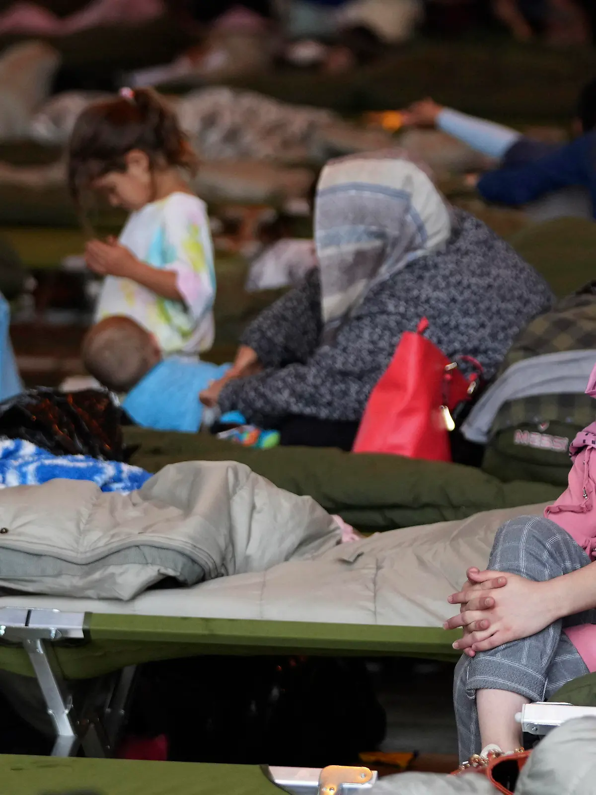 A recently evacuated Afghan girl sits on a bench at the Ramstein U.S. Air Base, Germany, Tuesday, Aug. 24, 2021.The largest American military community overseas housed thousands Afghan evacuees in an increasingly crowded tent city. (AP Photo/Matthias Schrader)