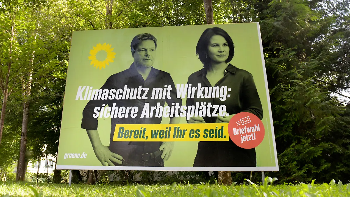  24.08.2021, Die Deutsche Bundestagswahl 2021 wirft ihre Schatten voraus, Wahlplakate säumen die Strassen in Bad Wörishofen im Unterallgäu, hier ein Plakat der Grünen mit Kanzlerkandidatin Annalena Baerbock und Robert Habeck in einem Park inmitten grüner Laubbäume. Klimaschutz mit Wirkung: Sichere Arbeitsplätze 24.08.2021, Bundestagswahl 2021 im September 24.08.2021, Bundestagswahl 2021 im September *** 24 08 2021, The German federal election 2021 casts its shadow ahead, election posters line the streets in Bad Wörishofen in Unterallgäu, here a poster of the Green Party with chancellor candidate Annalena Baerbock and Robert Habeck in a park surrounded by green deciduous trees Climate protection with effect Secure jobs 24 08 2021,