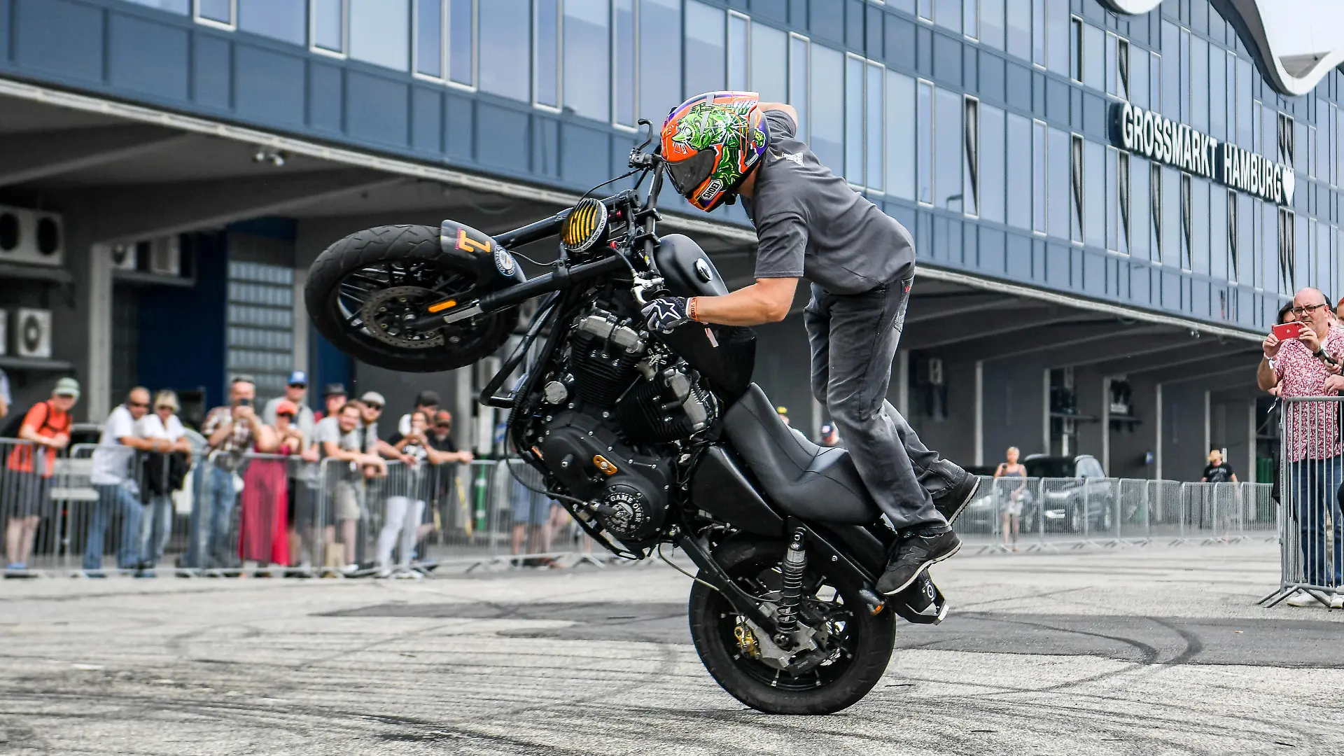 Ein Motorradfahrer bäumt seine Maschine zum Wheelie auf.