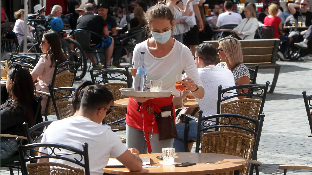 Aufgrund anhaltend niedriger Inzidenzen in Heidelberg durften gastronomische Betriebe ihren Außenbereich wieder öffnen, sofern Gäste einen negativen Coronatest vorweisen konnten. Eine Kellnerin eines Restaurants in der Innenstadt bringt Getränke an einen besetzten Tisch, Baden Württemberg, Deutschland *** Due to persistently low incidence rates in Heidelberg, catering establishments were allowed to reopen their outdoor areas if guests could show a negative coronal test A waitress at a downtown restaurant brings drinks to an occupied table, Baden Württemberg, Germany