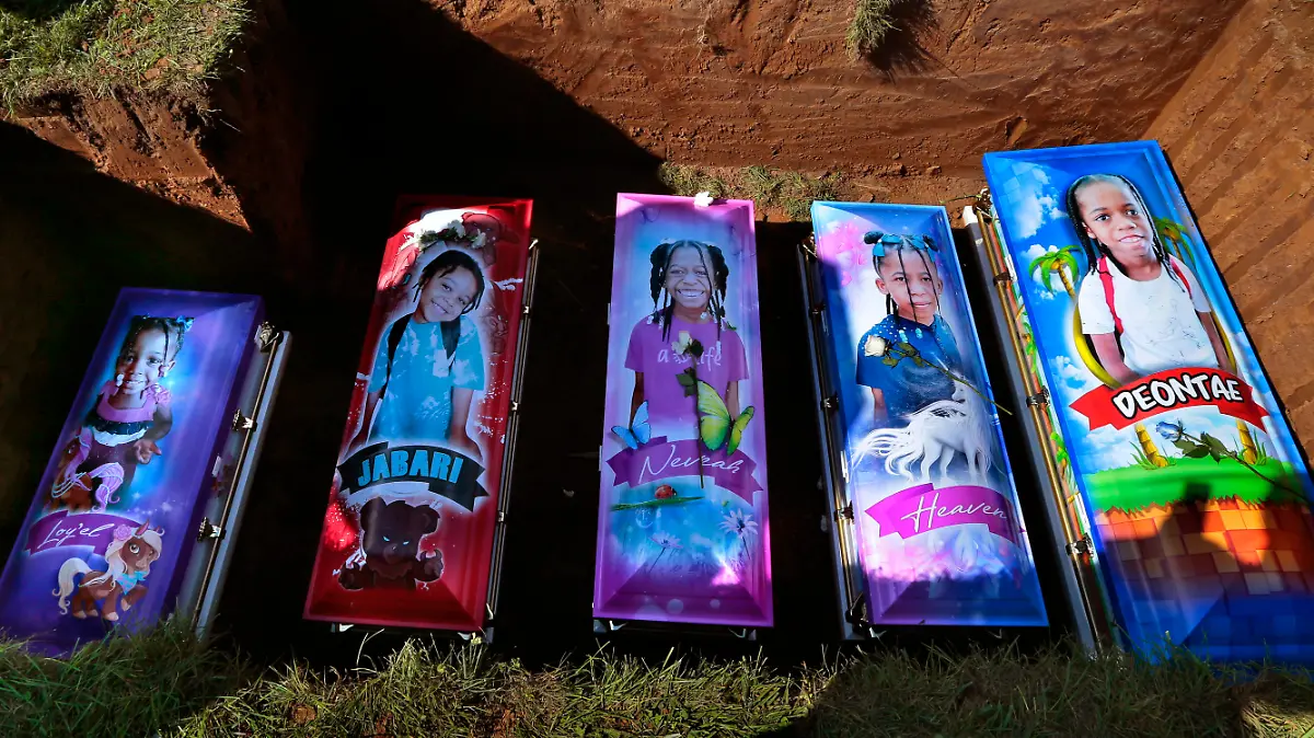 Cemetery workers prepare to cover the caskets of five children at Sunset Gardens of Memory Cemetery in Millstadt, Ill. on Saturday, Aug. 21, 2021 after they died in a predawn fire in East St. Louis on Aug. 6. Sabrina Dunigan's five children - Loy'el Dunigan, 2, Jabari Johnson 4, twin sisters Heaven and Neveah "Veah" Dunigan, 8, and Deontae Davis, 9, were killed in the fire while Dunigan was picking up her boyfriend. Their grandfather and his wife jumped from the apartment's second floor. (Robert Cohen/St. Louis Post-Dispatch via AP)