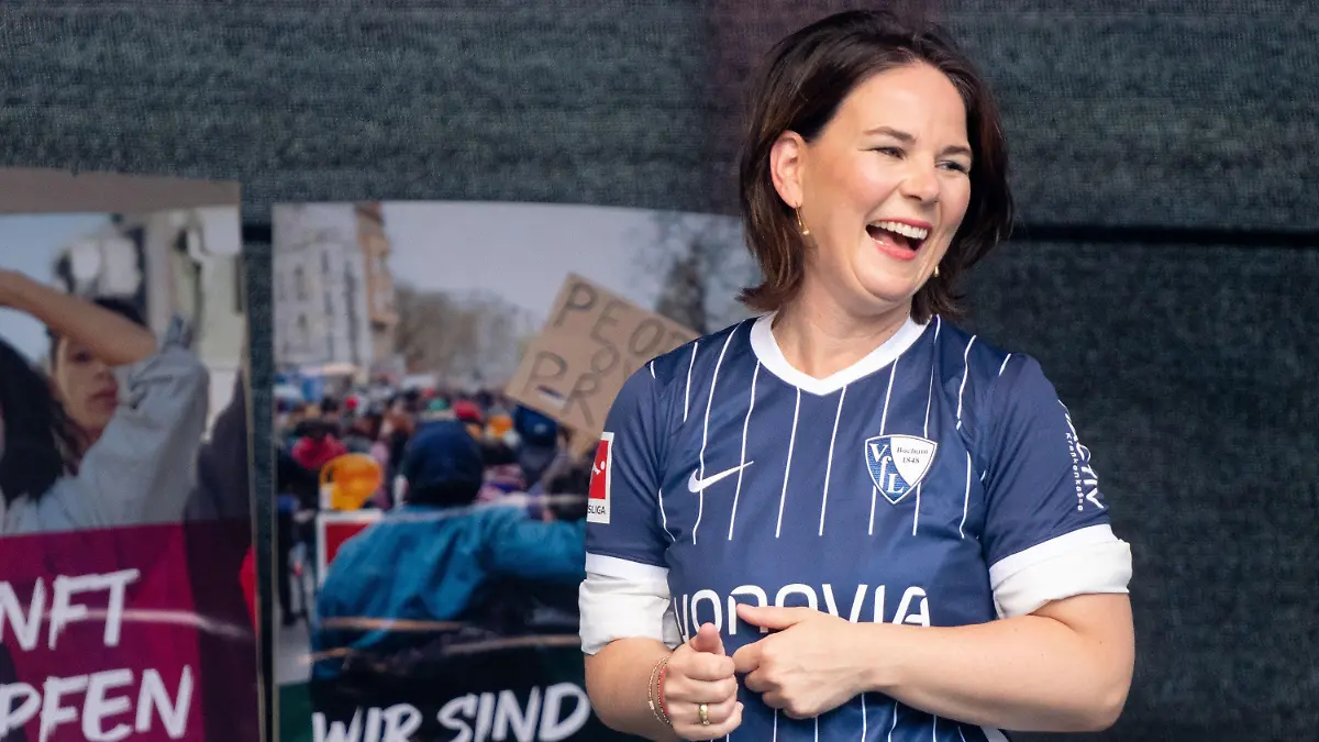10.08.2021, Nordrhein-Westfalen, Bochum: Annalena Baerbock, Kanzlerkandidatin und Bundesvorsitzende von Bündnis 90/Die Grünen, steht mit dem Trikot des VfL Bochum bei einem Wahlkampftermin vor dem Deutschen Bergbau-Museum auf der Bühne. Foto: Kay Nietfeld/dpa +++ dpa-Bildfunk +++