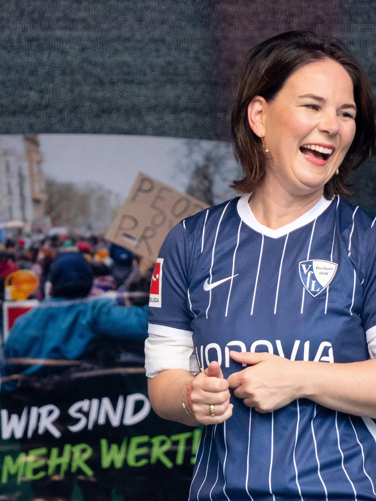 10.08.2021, Nordrhein-Westfalen, Bochum: Annalena Baerbock, Kanzlerkandidatin und Bundesvorsitzende von Bündnis 90/Die Grünen, steht mit dem Trikot des VfL Bochum bei einem Wahlkampftermin vor dem Deutschen Bergbau-Museum auf der Bühne. Foto: Kay Nietfeld/dpa +++ dpa-Bildfunk +++