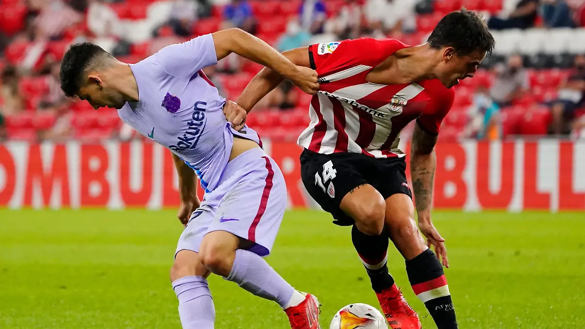 Soccer Football - LaLiga - Athletic Bilbao v FC Barcelona - San Mames, Bilbao, Spain - August 21, 2021 Athletic Bilbao's Dani Garcia  in action with FC Barcelona's Yusuf Demir REUTERS/Vincent West