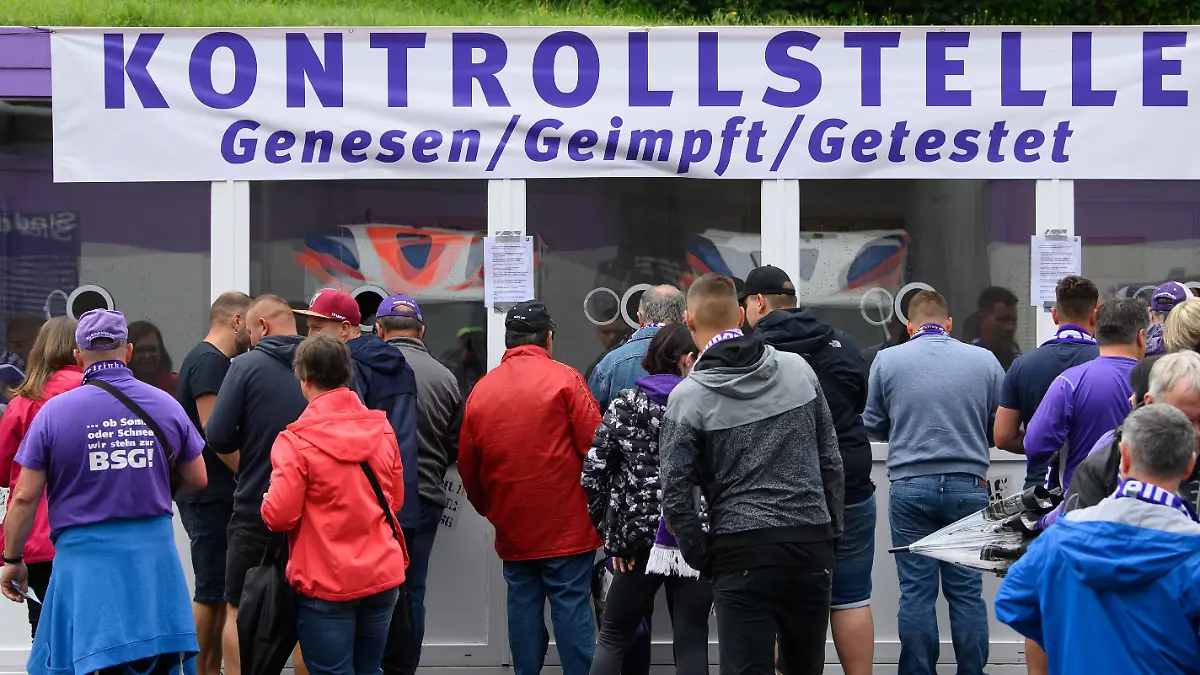 Fußball: 2. Bundesliga, FC Erzgebirge Aue - FC St. Pauli, 2. Spieltag, im Erzgebirgsstadion. Auer Fans stehen vor dem Stadion an einer "Kontrollstelle für Genesen, Geimpft und Getestet" an, um sich zu registrieren.