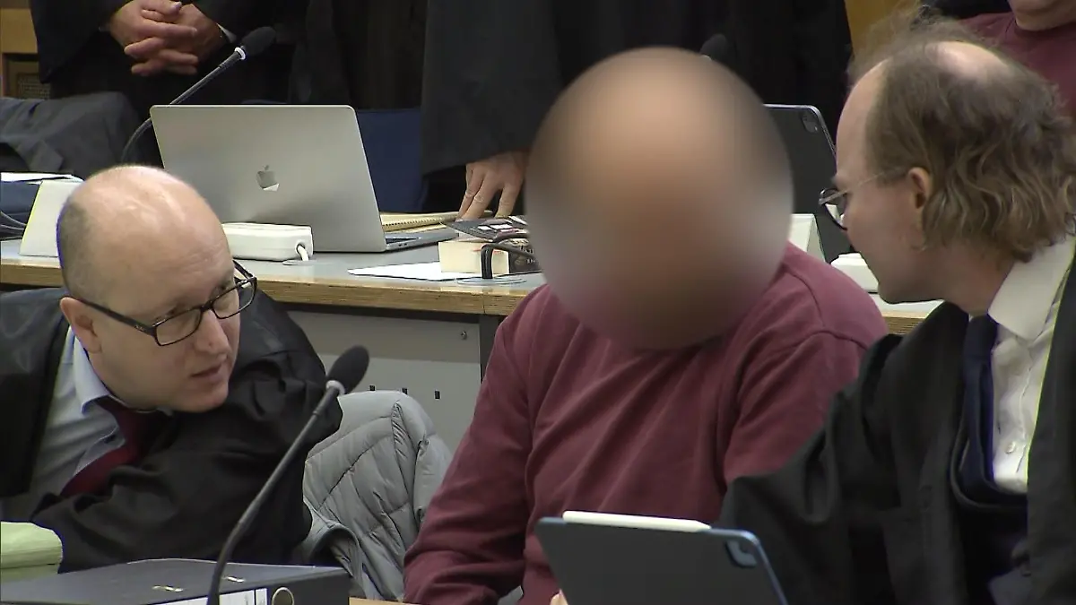 Einer der Mitangeklagten berät sich im Gerichtssaal am Mittwoch mit seinen Anwälten.