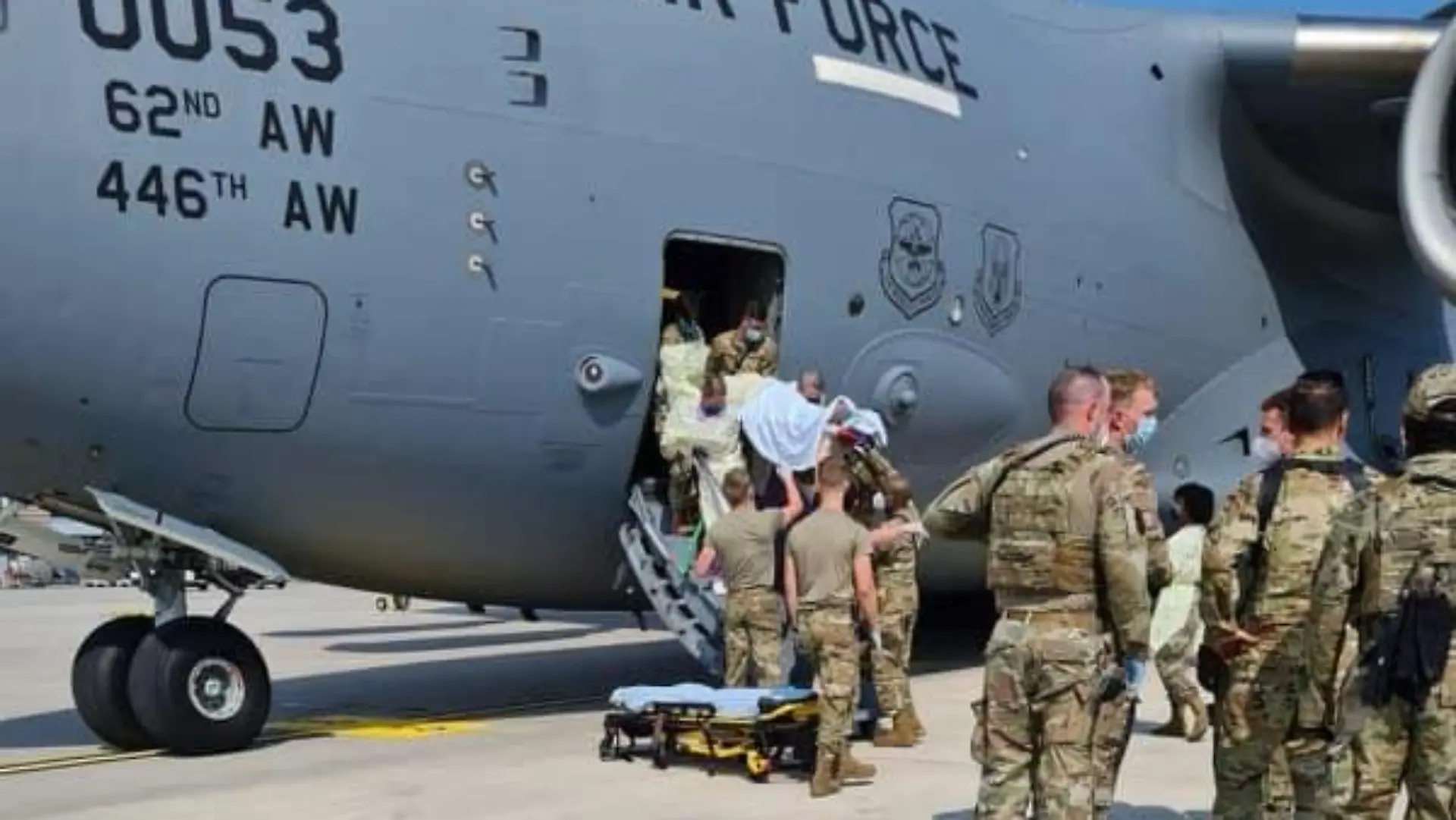 HANDOUT - 22.08.2021, Rheinland-Pfalz, Ramstein: Am 22.08. zur Verfügung gestelltes Handout zeigt US-Soldaten, die auf dem US-Stützpunkt Ramstein eine Person aus einem US-Flugzeug tragen. Eine afghanische Frau hat an Bord eines US-Evakuierungsflugzeugs ein Baby zur Welt gebracht. (bestmögliche Qualität) Foto: -/Air Mobility Command /dpa - ACHTUNG: Nur zur redaktionellen Verwendung im Zusammenhang mit der aktuellen Berichterstattung und nur mit vollständiger Nennung des vorstehenden Credits +++ dpa-Bildfunk +++