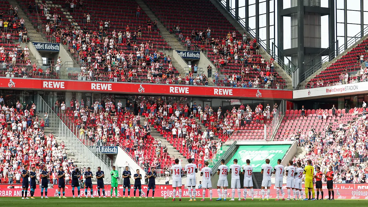 15.08.2021, Nordrhein-Westfalen, Köln: Fußball: Bundesliga, 1. FC Köln - Hertha BSC, 1. Spieltag im RheinEnergieStadion: Die Spieler stehen bei einer Gedenkminute für Gerd Müller auf dem Platz. Foto: Rolf Vennenbernd/dpa - WICHTIGER HINWEIS: Gemäß den Vorgaben der DFL Deutsche Fußball Liga bzw. des DFB Deutscher Fußball-Bund ist es untersagt, in dem Stadion und/oder vom Spiel angefertigte Fotoaufnahmen in Form von Sequenzbildern und/oder videoähnlichen Fotostrecken zu verwerten bzw. verwerten zu lassen. +++ dpa-Bildfunk +++
