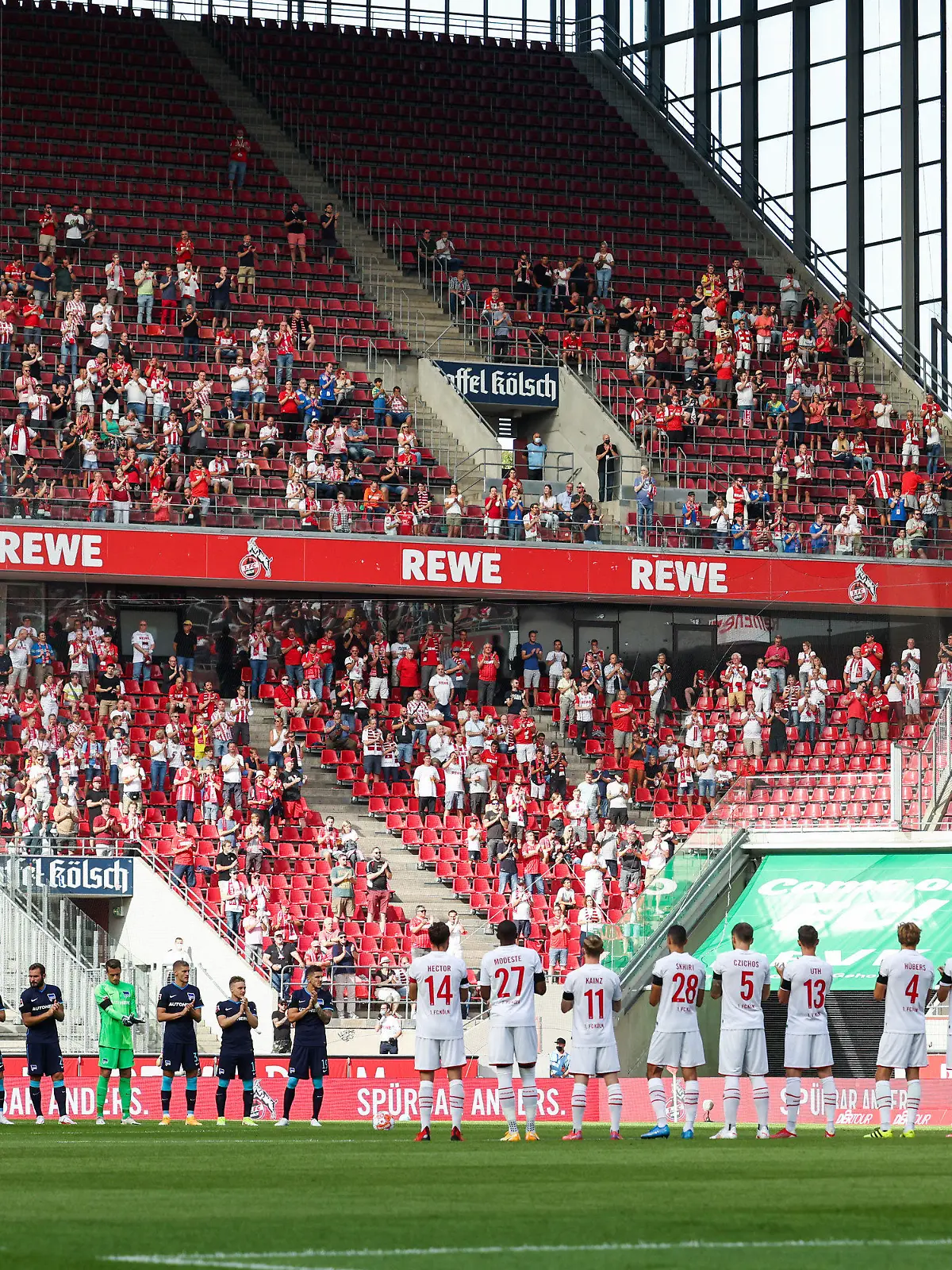 15.08.2021, Nordrhein-Westfalen, Köln: Fußball: Bundesliga, 1. FC Köln - Hertha BSC, 1. Spieltag im RheinEnergieStadion: Die Spieler stehen bei einer Gedenkminute für Gerd Müller auf dem Platz. Foto: Rolf Vennenbernd/dpa - WICHTIGER HINWEIS: Gemäß den Vorgaben der DFL Deutsche Fußball Liga bzw. des DFB Deutscher Fußball-Bund ist es untersagt, in dem Stadion und/oder vom Spiel angefertigte Fotoaufnahmen in Form von Sequenzbildern und/oder videoähnlichen Fotostrecken zu verwerten bzw. verwerten zu lassen. +++ dpa-Bildfunk +++