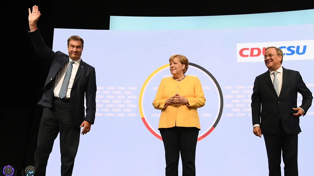 CSU party chief Markus Soeder waves as he stands next to German Chancellor Angela Merkel and Prime Minister of North Rhine-Westphalia and candidate for chancellor of the CDU/CSU Armin Laschet during a CDU/CSU campaign kick off ahead of the federal election at Tempodrom in Berlin, Germany, August 21, 2021. REUTERS/Annegret Hilse