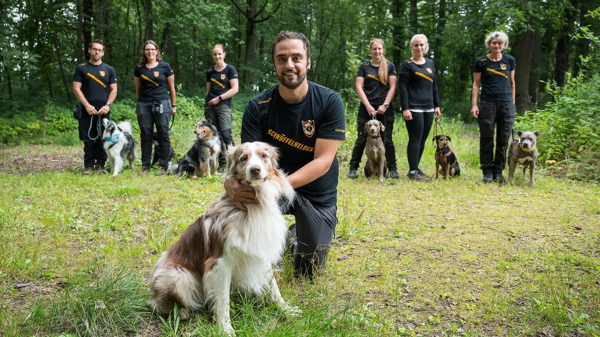 16.08.2021, Saarland, Püttlingen: Mitglieder des Vereins Schnüffelhelden stehen mit ihren Hunden am Waldrand. Der Verein hilft beim Auffinden von entlaufenen Hunden. (Zu dpa "«Schnüffelhelden» im Einsatz für vermisste Hunde") Foto: Oliver Dietze/dpa +++ dpa-Bildfunk +++