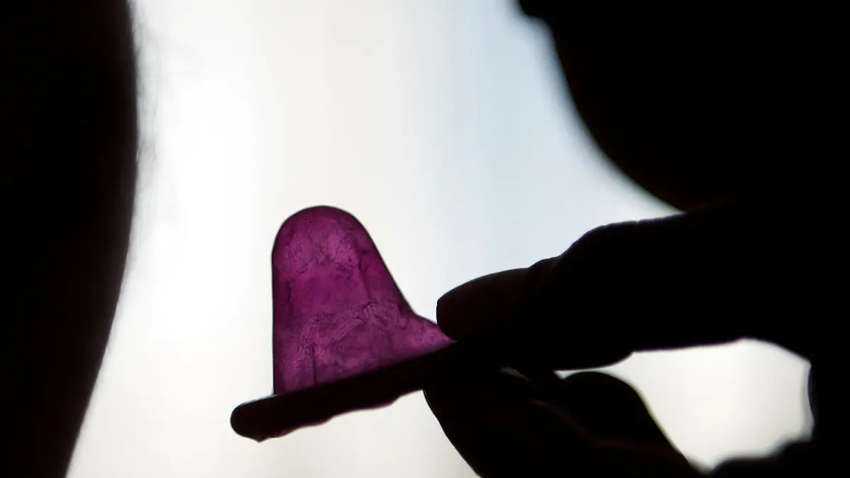 Eine Frau hält ein Kondom vor dem Geschlechtsakt mit ihrem Partner, aufgenommen am 07.05.2011 in Leipzig. Das Benutzen von Kondomen ist die einfachste Art sich vor HIV (Humanes Immundefizienz-Virus), Aids (Acquired Immune Deficiency Syndrome) und anderen Geschlechtskrankheiten zu schützen.   Foto: Peter Endig