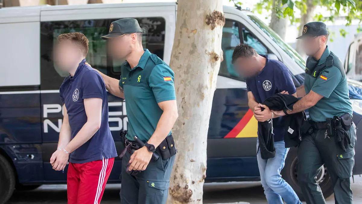 Zwei der insgesamt dreizehn Urlauber aus Deutschland bei einer Haftvorführung auf Mallorca. Den Männern wird vorgeworfen, Zigarettenkippen auf ein Schilfrohrdach geworfen und so einen Brand ausgelöst zu haben.