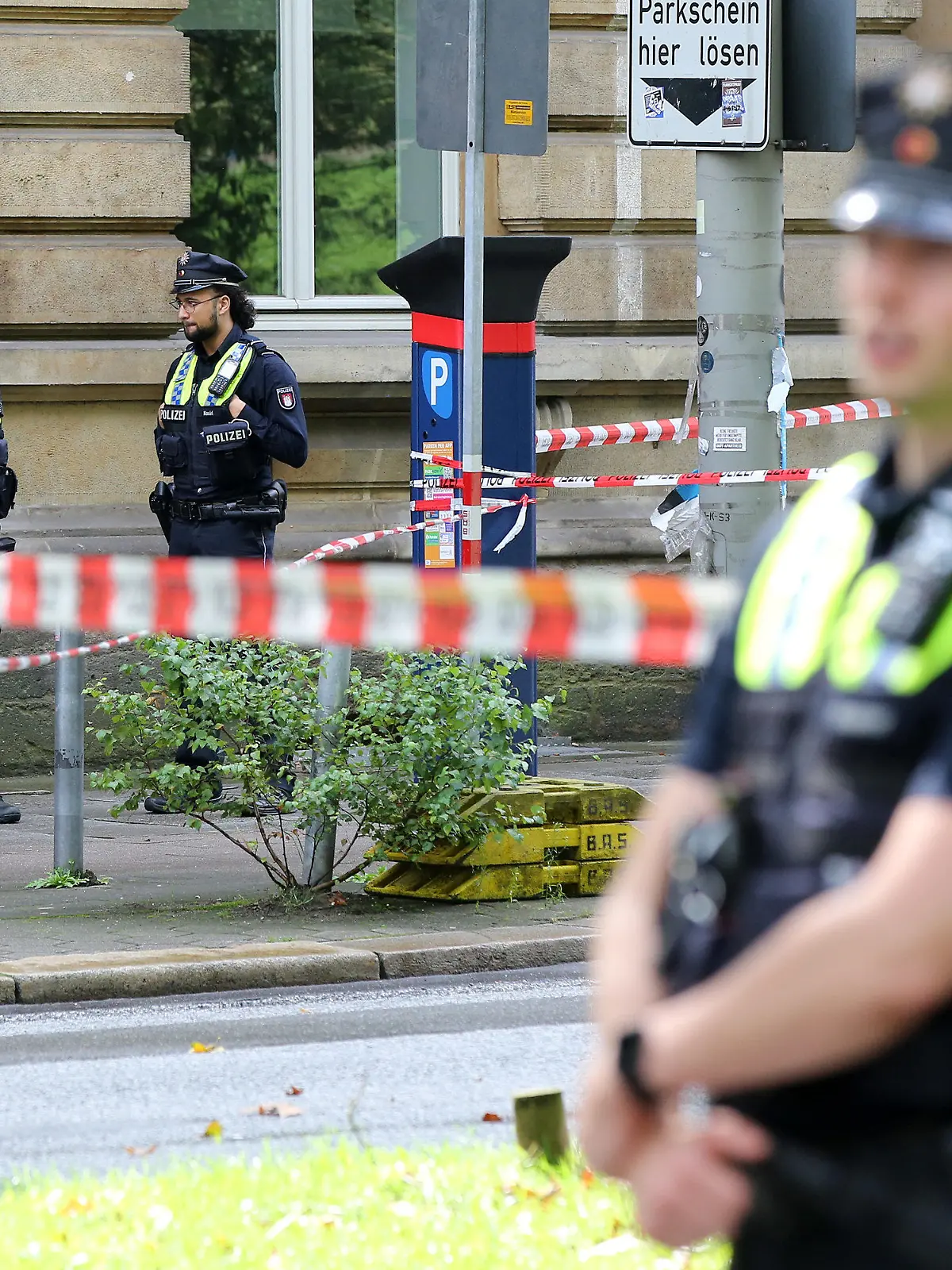 20.08.2021, Hamburg: Einsatzkräfte stehen an einer Polizeiabsperrung auf dem Gorch-Fock-Wall. Zeugen haben am Freitag im Hamburger Zentrum Schüsse gehört - ein großer Polizeieinsatz ist angelaufen. Im Bereich Gorch-Fock-Wall waren offenbar Schüsse gefallen, sagte eine Polizeisprecherin zu entsprechenden Medienberichten. Umfassende Fahndungsmaßnahmen laufen. Foto: Bodo Marks/dpa +++ dpa-Bildfunk +++
