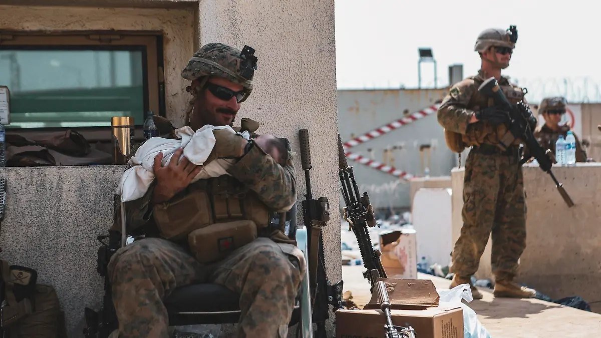 Ein Soldat schaukelt ein Neugeborenes am Flughafen von Kabul