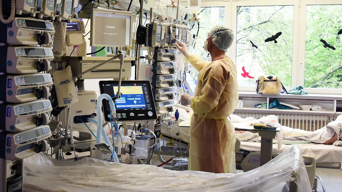 12.05.2021, Sachsen-Anhalt, Halle (Saale): Im Krankenhaus St. Elisabeth und St. Barbara Halle/Saale überprüft der Fachkrankenpfleger für Anästhesie und Intensivpflege Friedrich neben einen leeren Bett auf der Interdisziplinären Intensivstation mit Covid-19-Bereich einen Infusions-und Spritzenpumpenturm am Bett eines Patienten. Auf der Station ist seit dem heutigen Tag eine deutliche Entspannung zu spüren, was die Belegung durch Patienten mit Covid-19 betrifft. Foto: Waltraud Grubitzsch/dpa-Zentralbild/dpa +++ dpa-Bildfunk +++