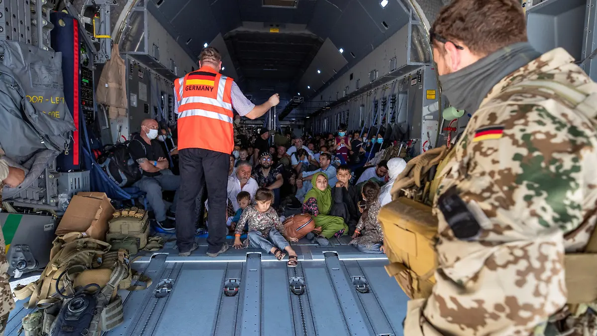 A handout photo obtained from the Bundeswehr Twitter account @Bw_Einsatz on August 18, 2021 shows staff talking to evacuees from Afghanistan as they arrive in an Airbus A400 transport aircraft of the German Air Force Luftwaffe in Tashkent, Uzbekistan. Marc Tessensohn/Twitter @Bw_Einsatz/Handout via REUTERS ATTENTION EDITORS - THIS IMAGE HAS BEEN SUPPLIED BY A THIRD PARTY. NO RESALES. NO ARCHIVES