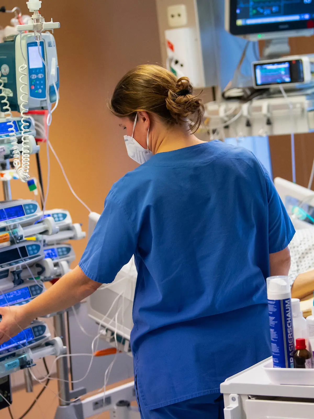 30.12.2020, Bayern, Gauting: Eine Intensivpflegerin versorgt auf der Intensivstation der Asklepios Klinik einen nicht-infektiösen Patienten. Der Patient liegt im künstlichen Koma und wird beatmet. Foto: Sven Hoppe/dpa +++ dpa-Bildfunk +++
