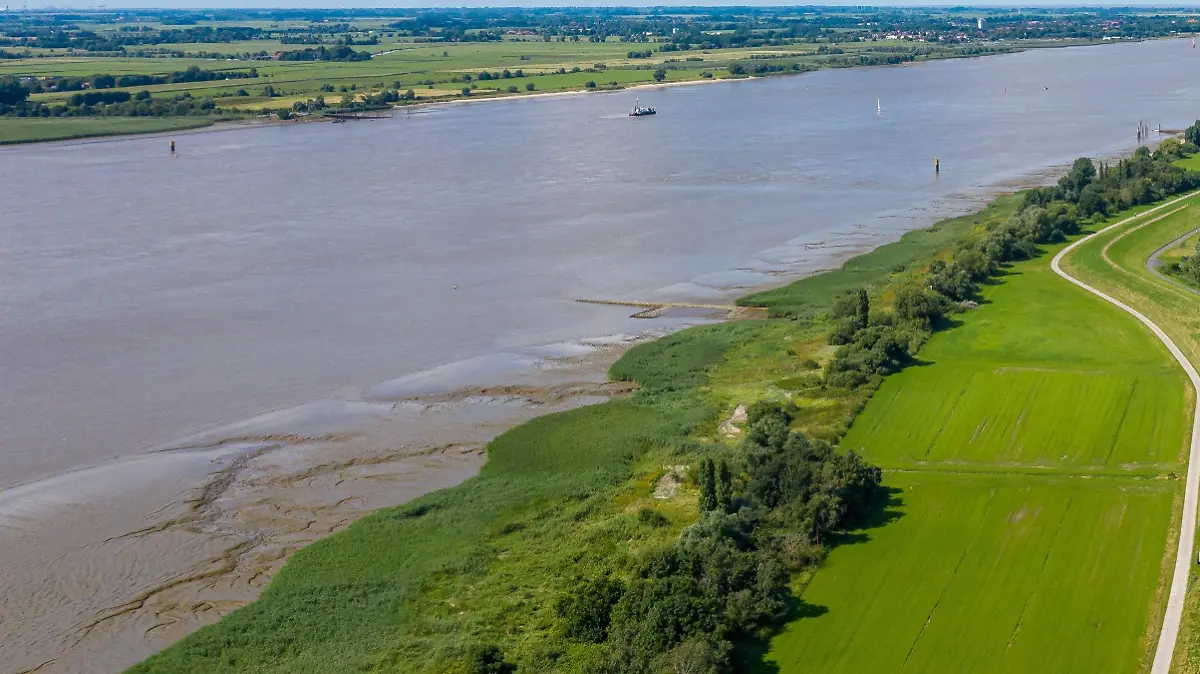 04.08.2021, Niedersachsen, Loxstedt: Die Weser zwischen Brake und Nordenham (Luftaufnahme mit einer Drohne). Um das Projekt der Weservertiefung wird seid über einem Jahrzehnt gestritten, auch vor Gericht. Es geht um die Vertiefung der Weser von der Nordsee nach Bremerhaven und von Bremerhaven weseraufwärts bis nach Brake. Umweltschützer warnen vor katastrophalen Folgen, die Wirtschaft hält das Projekt aus Wettbewerbsgründen für dringend geboten. Foto: Sina Schuldt/dpa +++ dpa-Bildfunk +++