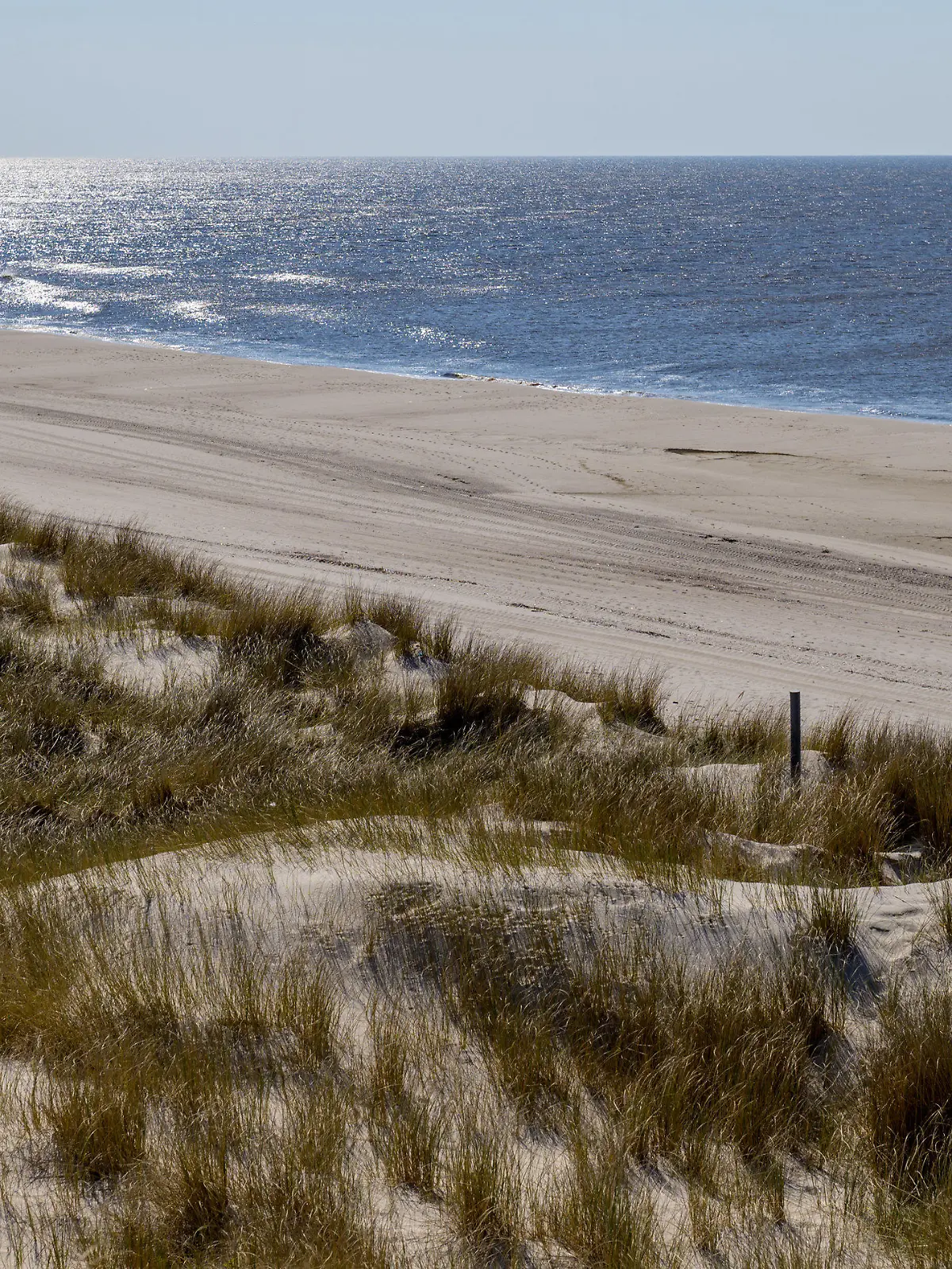 08.04.2019, Schleswig-Holstein, Wenningstedt/Sylt: Ein Mann läuft bei strahlendem Sonnenschein auf der Insel Sylt über einen ansonsten menschenleeren Strand Foto: Axel Heimken/dpa +++ dpa-Bildfunk +++