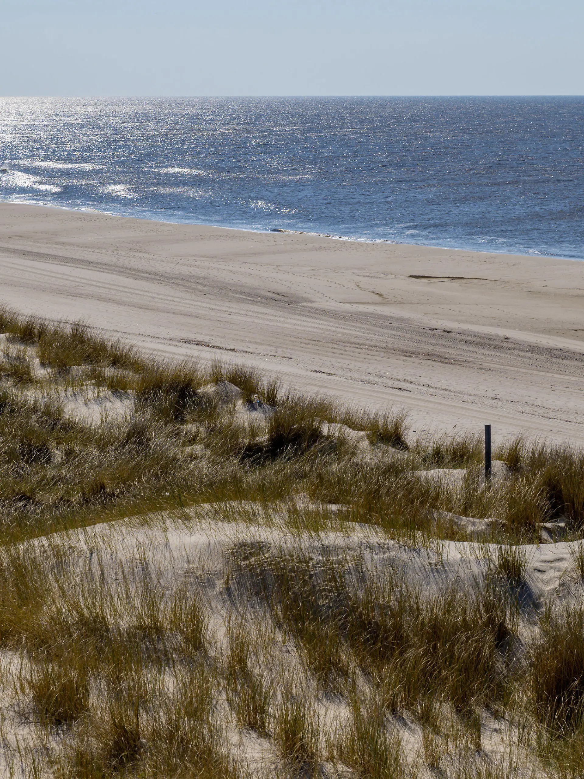 08.04.2019, Schleswig-Holstein, Wenningstedt/Sylt: Ein Mann läuft bei strahlendem Sonnenschein auf der Insel Sylt über einen ansonsten menschenleeren Strand Foto: Axel Heimken/dpa +++ dpa-Bildfunk +++