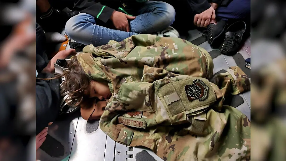 Ein Kind schläft auf dem Boden eines Militärfliegers der US Air Force.