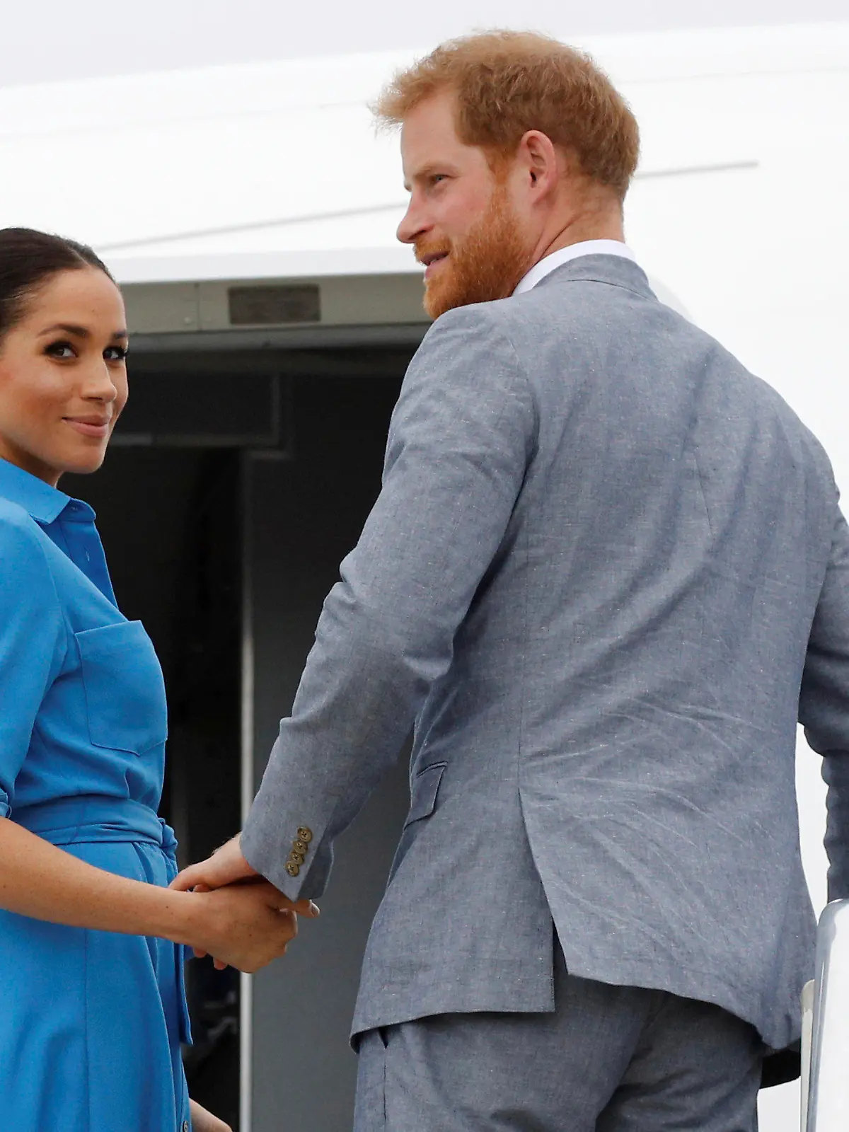 ARCHIV - 26.10.2018, Tonga, Nuku'alofa: Der britische Prinz Harry, Herzog von Sussex, und seine Frau Meghan, Herzogin von Sussex, besteigen am Flughafen Fua'amotu ihr Flugzeug. Am 4. August wird Meghan 40 Jahre alt. Foto: Phil Nobel/Reuters POOL/AP/dpa +++ dpa-Bildfunk +++