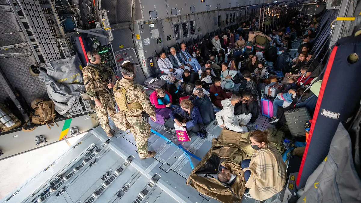 HANDOUT - 17.08.2021, Usbekistan, Taschkent: Aus Kabul evakuierte Personen warten nach der Landung mit einem Transportflugzeug Airbus A400M der Bundeswehr darauf, dass sie das Flugzeug verlassen können. Nach der Machtübernahme der Taliban in Afghanistan hat die Bundeswehr unter schwierigsten Bedingungen mit ihrer Luftbrücke zur Rettung von Deutschen und Afghanen begonnen. Foto: Marc Tessensohn/Bundeswehr/dpa - ACHTUNG: Nur zur redaktionellen Verwendung im Zusammenhang mit der aktuellen Berichterstattung und nur mit vollständiger Nennung des vorstehenden Credits +++ dpa-Bildfunk +++