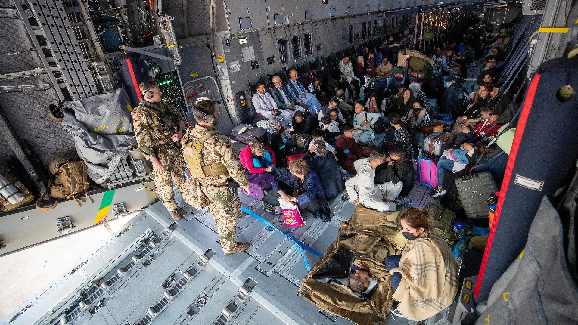 HANDOUT - 17.08.2021, Usbekistan, Taschkent: Aus Kabul evakuierte Personen warten nach der Landung mit einem Transportflugzeug Airbus A400M der Bundeswehr darauf, dass sie das Flugzeug verlassen können. Nach der Machtübernahme der Taliban in Afghanistan hat die Bundeswehr unter schwierigsten Bedingungen mit ihrer Luftbrücke zur Rettung von Deutschen und Afghanen begonnen. Foto: Marc Tessensohn/Bundeswehr/dpa - ACHTUNG: Nur zur redaktionellen Verwendung im Zusammenhang mit der aktuellen Berichterstattung und nur mit vollständiger Nennung des vorstehenden Credits +++ dpa-Bildfunk +++