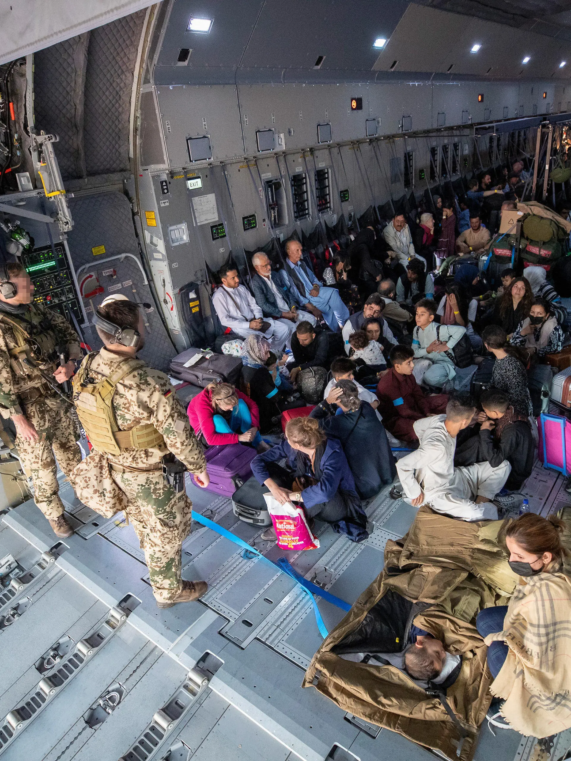 HANDOUT - 17.08.2021, Usbekistan, Taschkent: Aus Kabul evakuierte Personen warten nach der Landung mit einem Transportflugzeug Airbus A400M der Bundeswehr darauf, dass sie das Flugzeug verlassen können. Nach der Machtübernahme der Taliban in Afghanistan hat die Bundeswehr unter schwierigsten Bedingungen mit ihrer Luftbrücke zur Rettung von Deutschen und Afghanen begonnen. Foto: Marc Tessensohn/Bundeswehr/dpa - ACHTUNG: Nur zur redaktionellen Verwendung im Zusammenhang mit der aktuellen Berichterstattung und nur mit vollständiger Nennung des vorstehenden Credits +++ dpa-Bildfunk +++