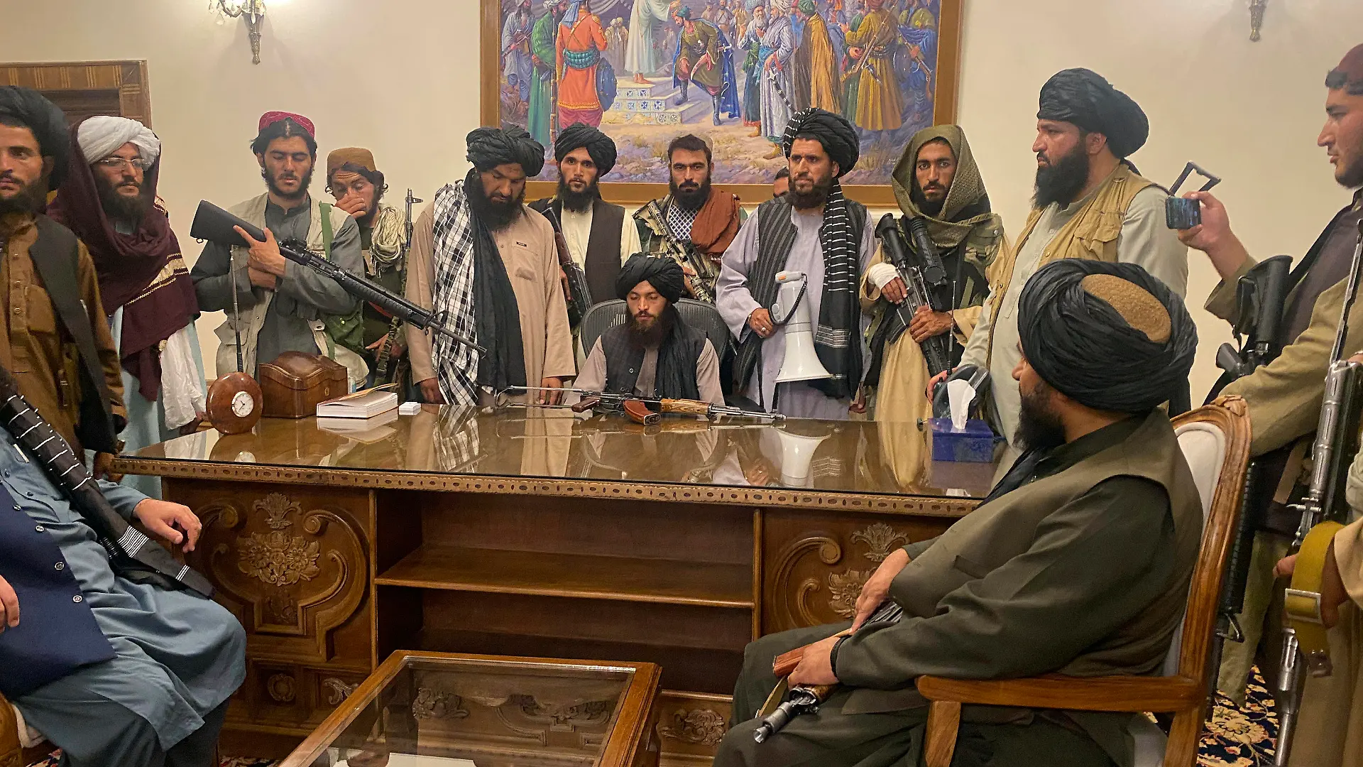 ARCHIV - 15.08.2021, Afghanistan, Kabul: Taliban-Kämpfer sitzen in einem Raum des Präsidentenpalastes. Nur wenige Stunden nach der Flucht des afghanischen Präsidenten Ghani haben Kämpfer der militant-islamistischen Taliban den Präsidentenpalast in der Hauptstadt Kabul eingenommen. (zu dpa: «Afghanischer Verein: «Es wird unter den Taliban keinen Frieden geben.») Foto: Zabi Karimi/AP/dpa +++ dpa-Bildfunk +++