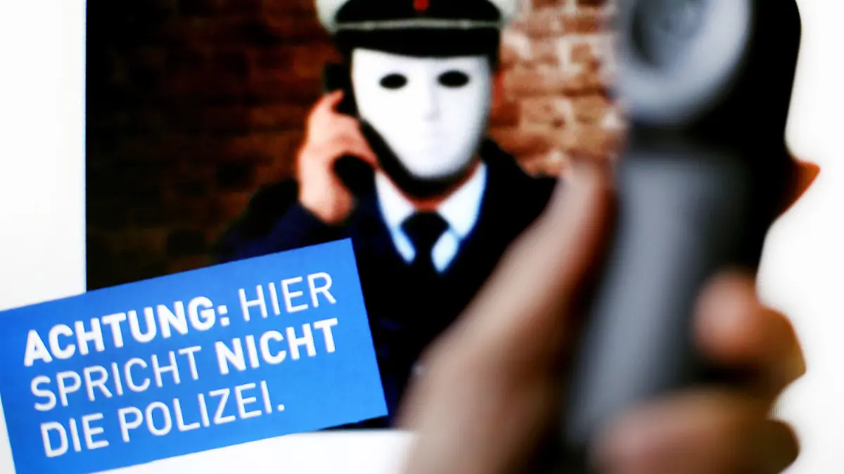 ARCHIV - 11.10.2017, Nordrhein-Westfalen, Düsseldorf: Ein Telefonhörer ist vor einem Plakat der Polizei NRW mit der Aufschrift «Achtung: Hier spricht NICHT die Polizei» zu sehen.  Mit der Betrugsmasche «falscher Polizist und Amtsträger» haben die Ermittler in Nordrhein-Westfalen in den ersten drei Quartalen 2019 bereits 284 vollendete Straftaten mit einer Schadenssumme von rund 11,2 Millionen Euro gezählt. Das berichtet die «Rheinische Post» (Donnerstag) mit Bezug auf das Landeskriminalamt (LKA). Foto: Martin Gerten/dpa +++ dpa-Bildfunk +++