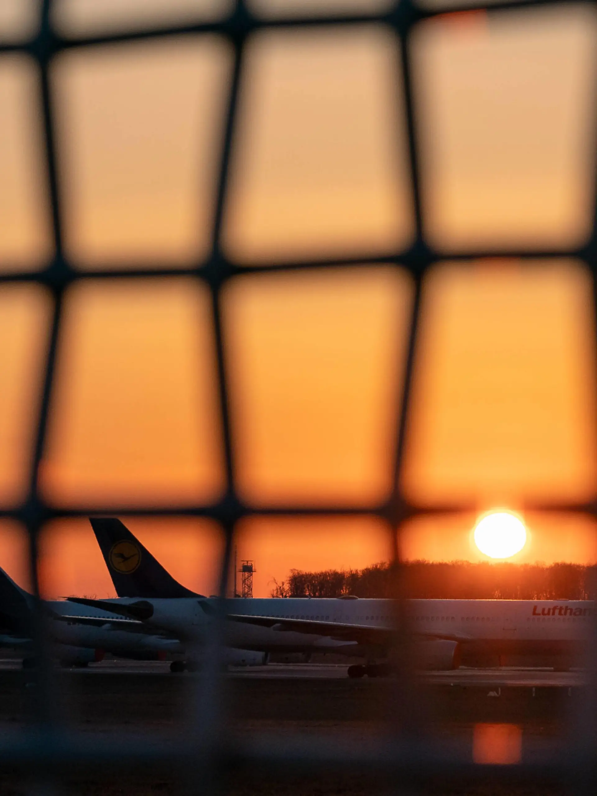  Impressionen Flughafen Frankfurt Rhein-Main 25.03.2020, Flughafen Frankfurt Rhein-Main : Maschinen, Flugzeuge der Lufthansa stehen am Boden der Nordwest Landebahn. Durch den eingeschränkten Flugverkehr weltweit wurde sie als Parkplatz umfunktioniert. Im Hintergrund die aufgehende Sonne in gelb orange. Aufgrund des Corona Virus Covid-19 ist der Flugverkehr weltweite stark eingeschränkt, teilweise ganz ausgesetzt. Derzeit sind aktuell ca. 31500 Personen infiziert, 149 sind verstorben. Frankfurt Hessen Germany Flughafen *** Impressions Frankfurt Rhein Main Airport 25 03 2020, Frankfurt Rhein Main Airport Aircraft, Lufthansa aircraft are standing on the ground of the northwest runway Due to the restricted air traffic worldwide, it has been converted into a parking lot In the background the rising sun in yellow orange Due to the Corona Viru