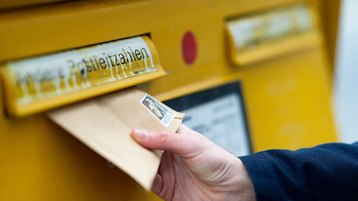 ARCHIV - 21.01.2019, Berlin: ILLUSTRATION - Ein Mann wirft einen Brief in einen Briefkasten.     (zu dpa "Porto, Kükentöten, Plastiktüten, Mindestlohn - Das ändert sich 2022") Foto: Monika Skolimowska/ZB/dpa +++ dpa-Bildfunk +++