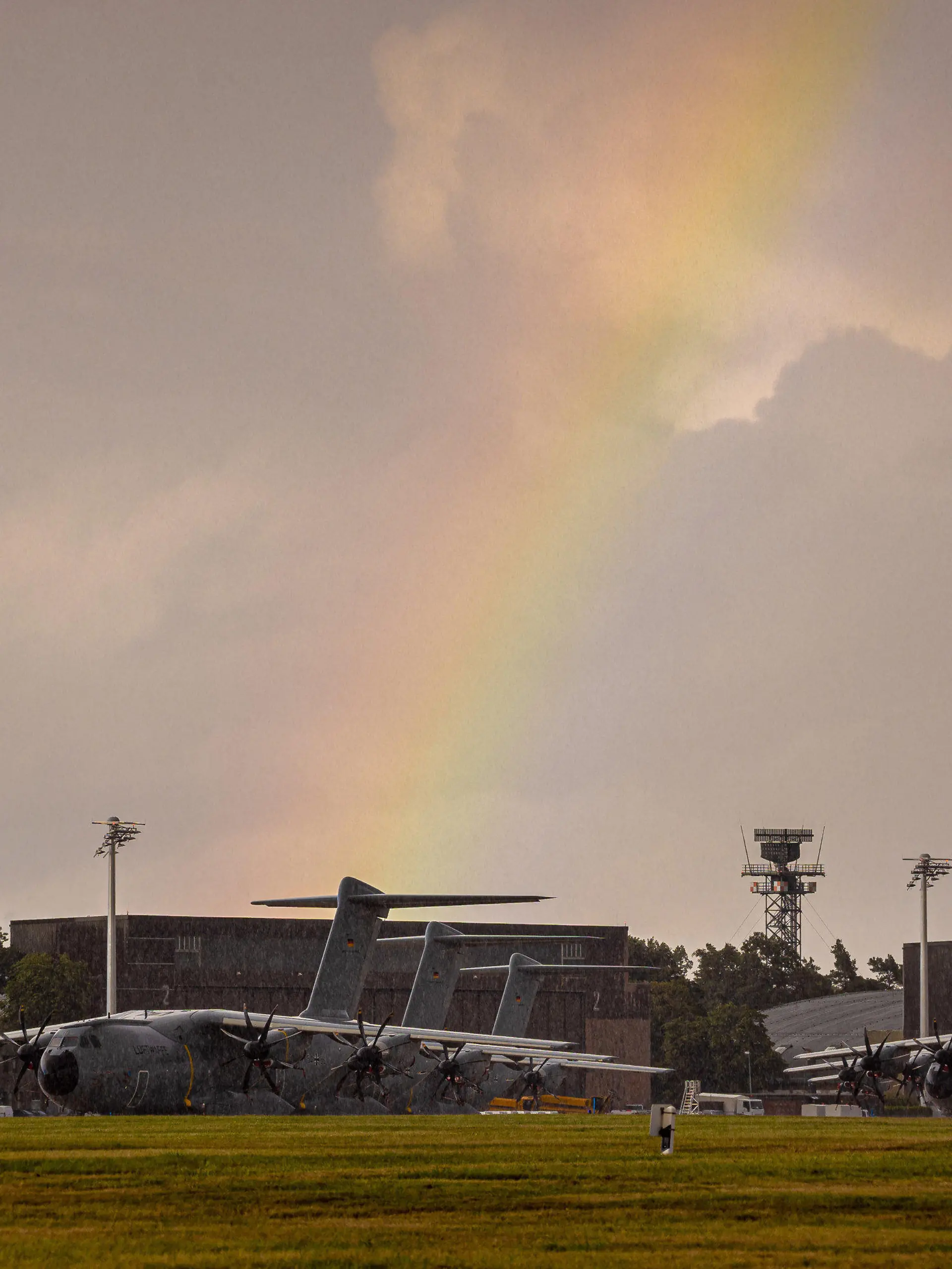 16.08.2021, Niedersachsen, Wunstorf: Ein Regenbogen spannt sich über Transportflugzeugen vom Typ Airbus A400M der Luftwaffe, die auf dem Fliegerhorst Wunstorf in der Region Hannover stehen. Angesichts des rasanten Vormarschs der Taliban in Afghanistan hat die Bundeswehr mit der Evakuierung deutscher Staatsbürger und afghanischer Ortskräfte aus Kabul begonnen. Foto: Moritz Frankenberg/dpa +++ dpa-Bildfunk +++