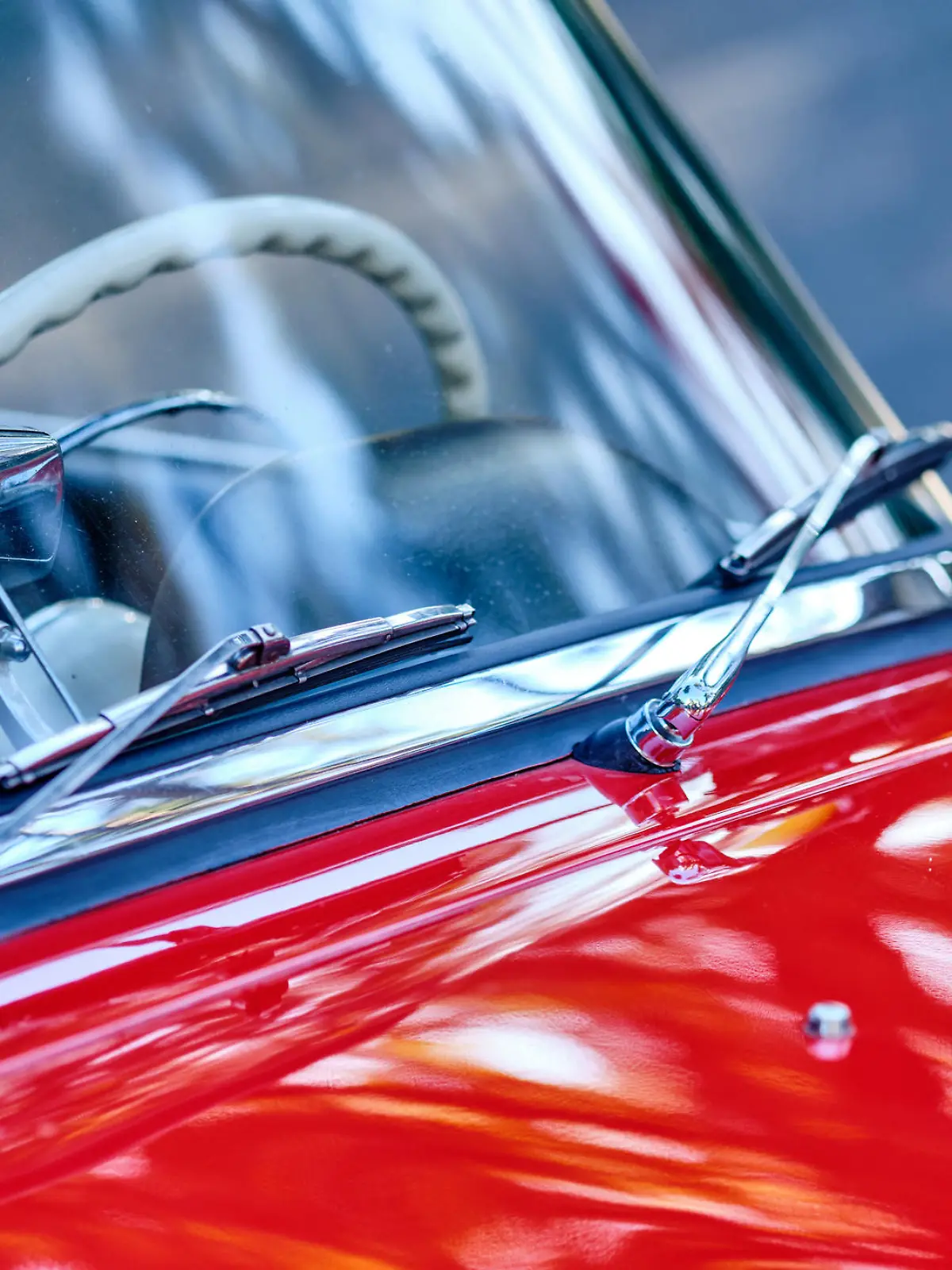 Windschutzscheibe eines roten Oldtimers. Nahaufnahme der Scheibenwischer.