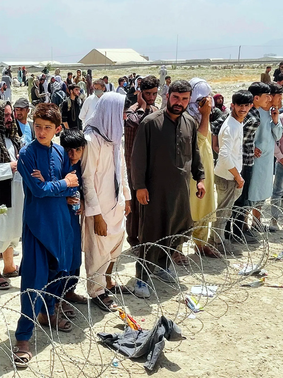 Hundreds of people gather outside the international airport in Kabul, Afghanistan, Tuesday, Aug. 17, 2021. The Taliban declared an “amnesty” across Afghanistan and urged women to join their government Tuesday, seeking to convince a wary population that they have changed a day after deadly chaos gripped the main airport as desperate crowds tried to flee the country. (AP Photo)