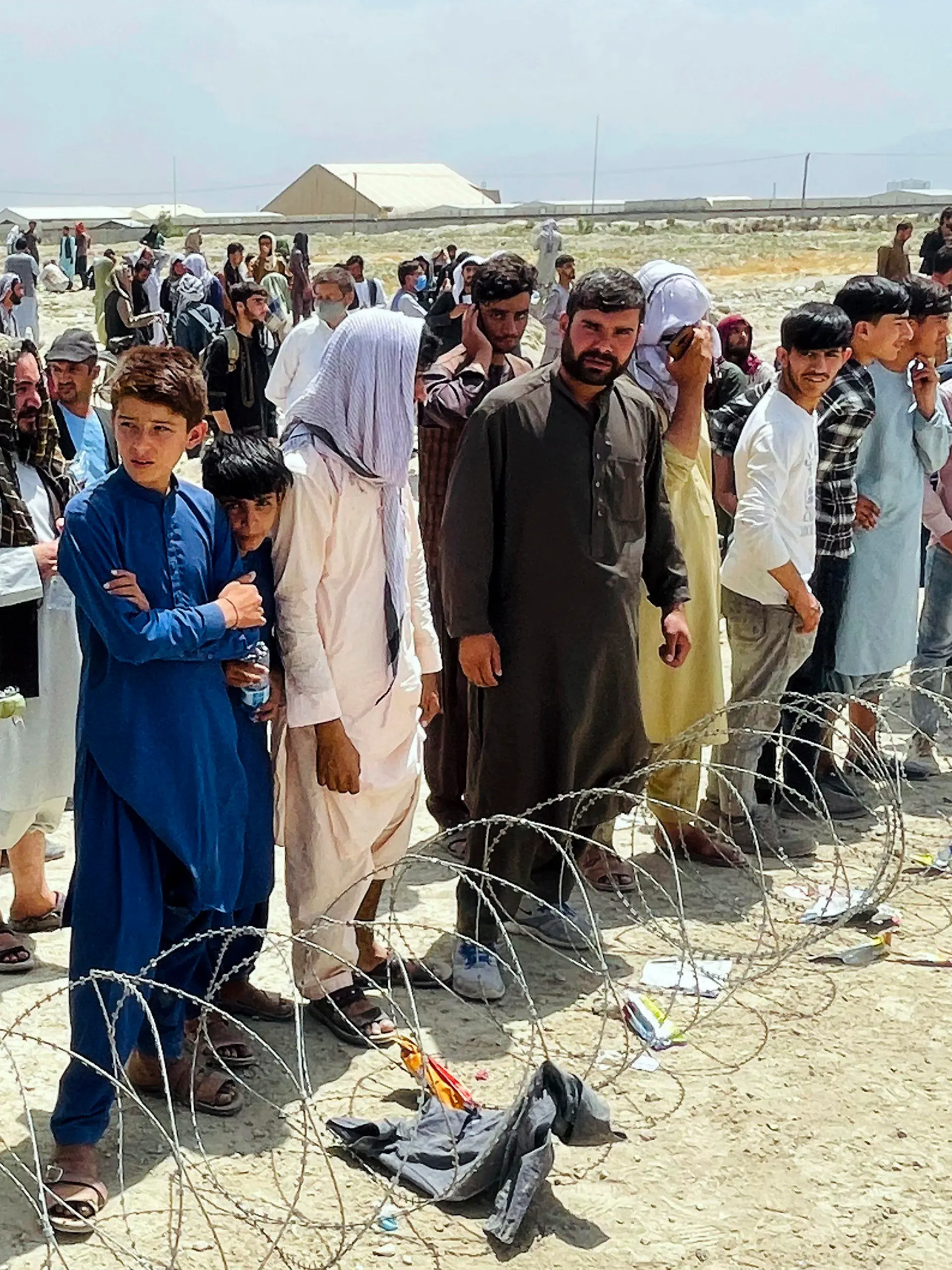 Hundreds of people gather outside the international airport in Kabul, Afghanistan, Tuesday, Aug. 17, 2021. The Taliban declared an “amnesty” across Afghanistan and urged women to join their government Tuesday, seeking to convince a wary population that they have changed a day after deadly chaos gripped the main airport as desperate crowds tried to flee the country. (AP Photo)