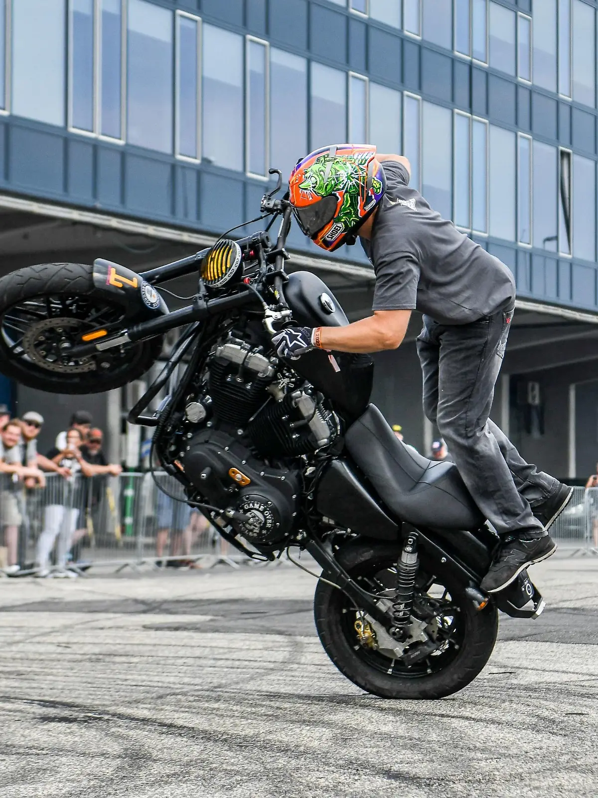 Ein Motorradfahrer richtet seine Maschine zu einem Wheelie auf.