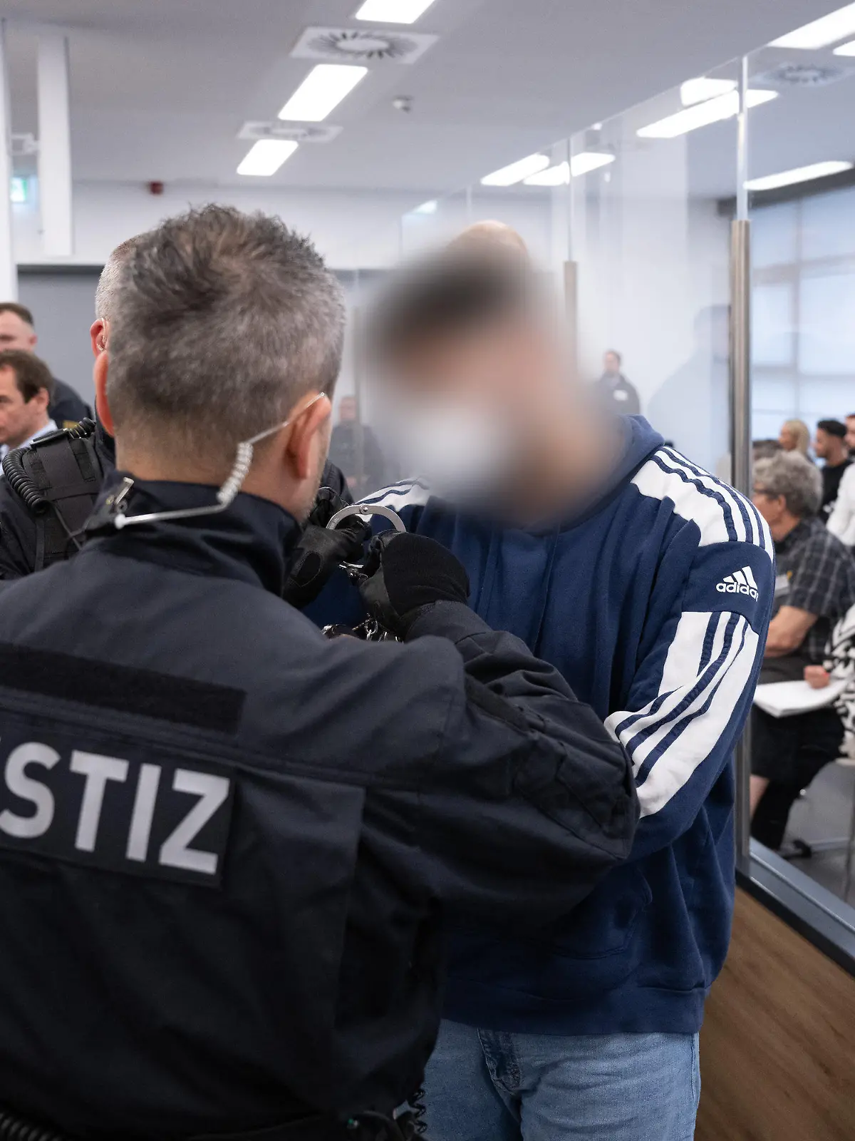 16.05.2023, Sachsen, Dresden: Ein Angeklagter (r) im Prozess um den Juwelenraub im Grünen Gewölbe wird bei der Fortsetzung des Prozess in den Verhandlungssaal im Landgericht geführt. Nach nahezu 50 Verhandlungstagen geht der Prozess um den Juwelendiebstahl aus dem Historischen Grünen Gewölbe Dresden zu Ende. Foto: Sebastian Kahnert/dpa - ACHTUNG: Person(en) wurde(n) aus rechtlichen Gründen gepixelt +++ dpa-Bildfunk +++