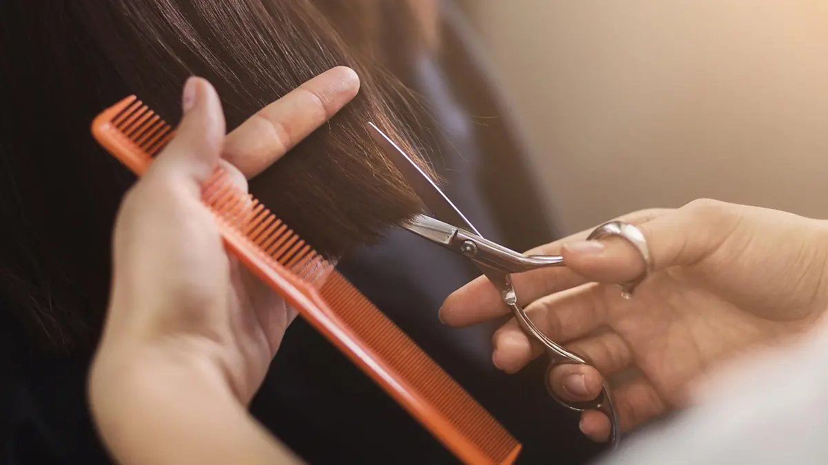 Friseur hält Schere und Kamm in der Hand