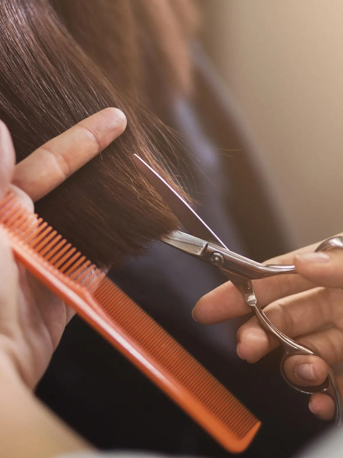Friseur hält Schere und Kamm in der Hand