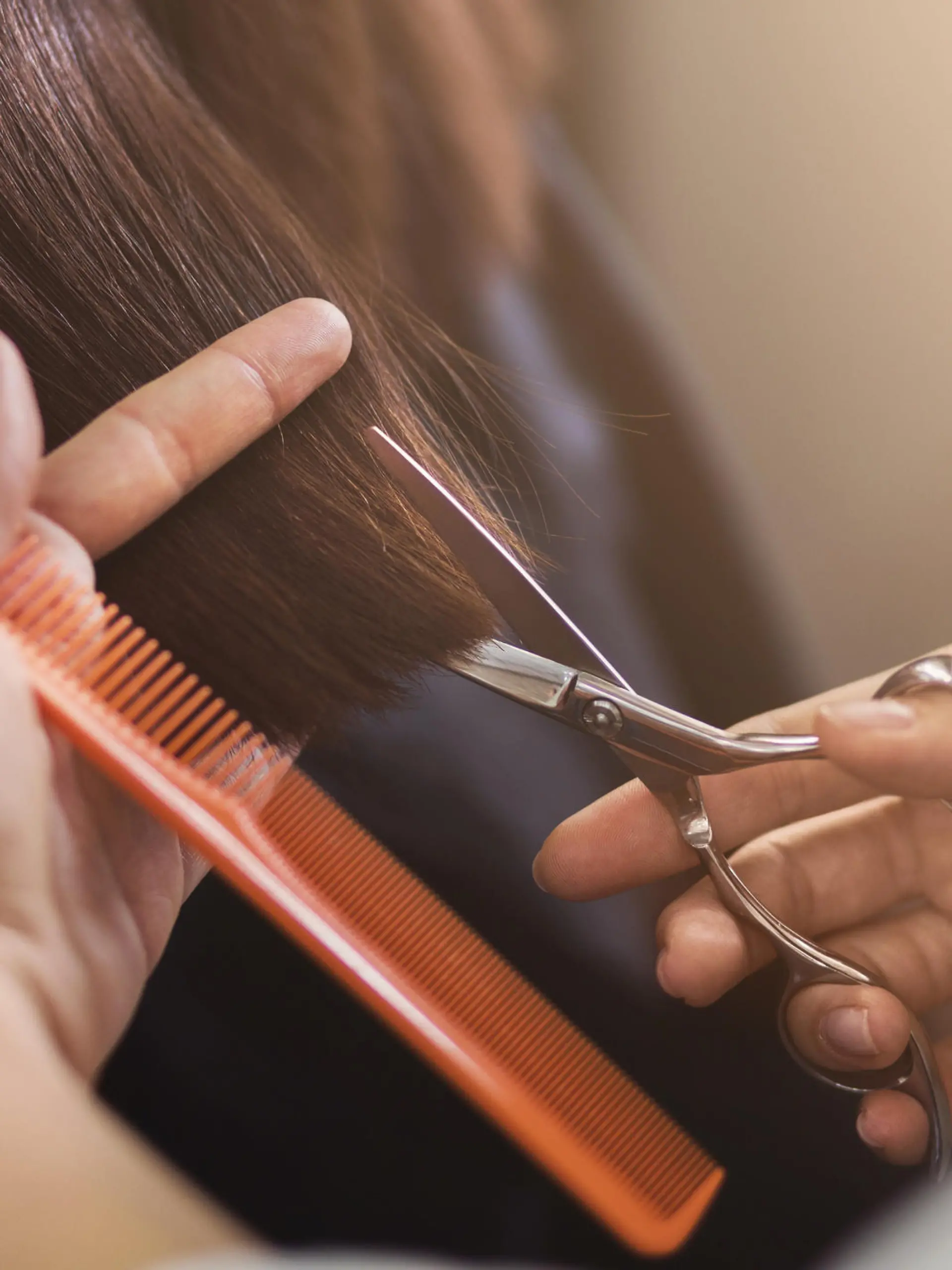 Friseur hält Schere und Kamm in der Hand