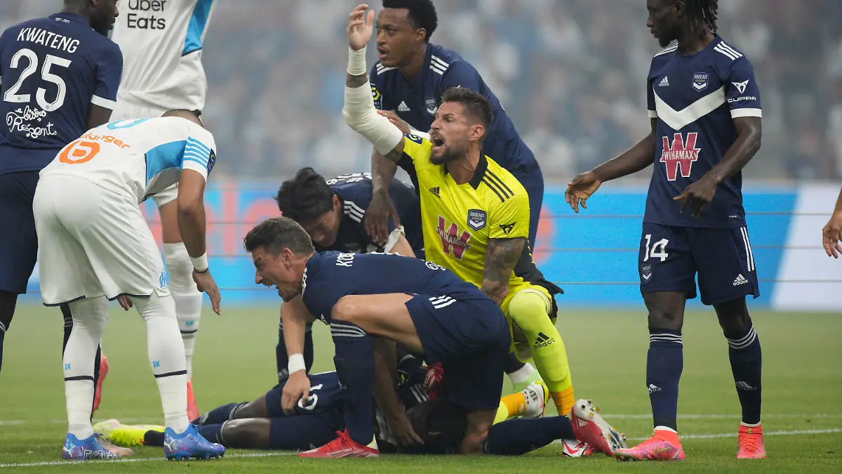 Bordeaux's Samuel Kalu lays on the pitch as players call the medic during the French League One soccer match between Marseille and Bordeaux at the Velodrome stadium in Marseille, southern France, Sunday, Aug. 15, 2021. (AP Photo/Daniel Cole)