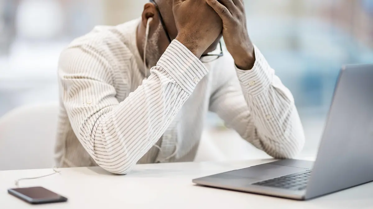 Mature businessman with earphones, smartphoen and laptop sitting with hands on head at desk model released Symbolfoto property released PUBLICATIONxINxGERxSUIxAUTxHUNxONLY FMKF05396