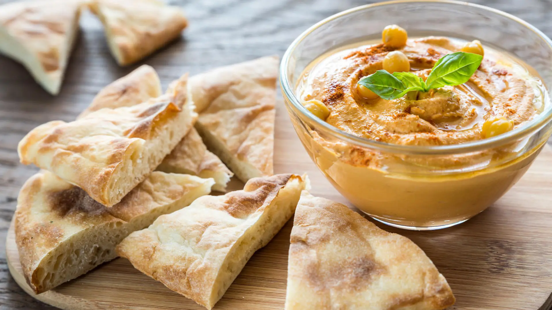 Bowl of hummus with pita slices