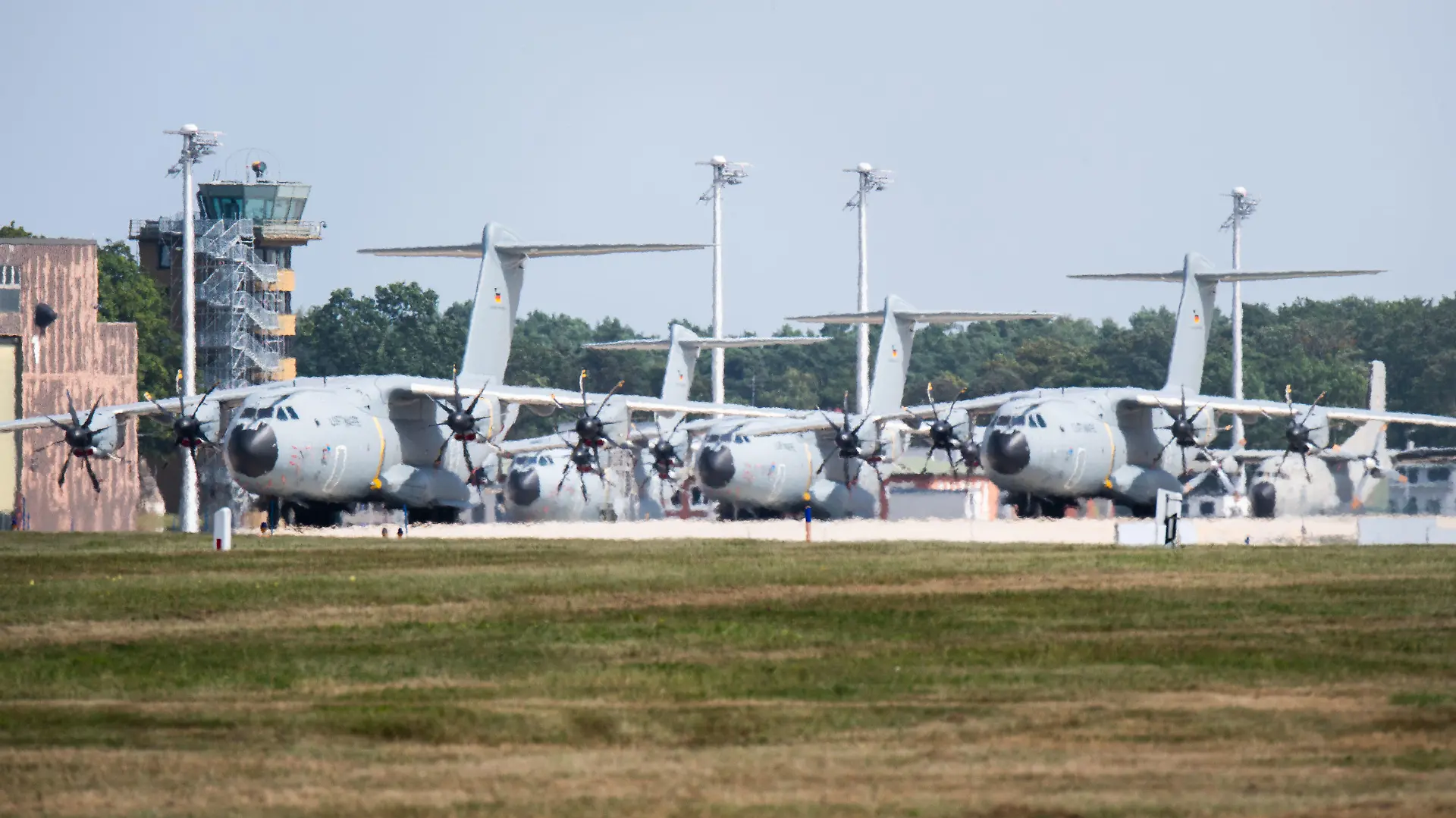 15.08.2021, Niedersachsen, Wunstorf: Transportflugzeuge vom Typ Airbus A400M der Luftwaffe stehen auf dem Fliegerhorst Wunstorf in der Region Hannover. Angesichts des rasanten Vormarschs der Taliban in Afghanistan will die Bundeswehr am Montag (16.08.2021) mit der Evakuierung deutscher Staatsbürger und afghanischer Ortskräfte aus Kabul beginnen. (ACHTUNG: Bestmögliche Qualität durch Hitzeflimmern) Foto: Julian Stratenschulte/dpa +++ dpa-Bildfunk +++