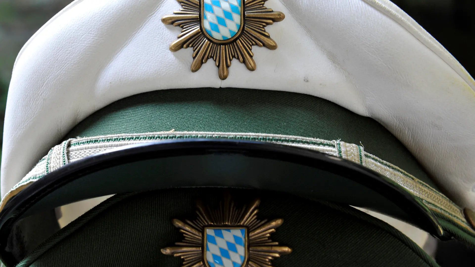 ILLUSTRATION - Polizeimützen liegen am Donnerstag (26.07.2012) auf einem Tisch einer Polizeistation in München (Oberbayern). Bayerns Polizei steht in den nächsten Jahren vor einer großen Pensionierungswelle. Bayerns Innenminister Herrmann will verhindern, dass aus Ruhestandsversetzungen ein Sicherheitsproblem wird. Foto: Frank Leonhardt dpa/lby +++(c) dpa - Bildfunk+++