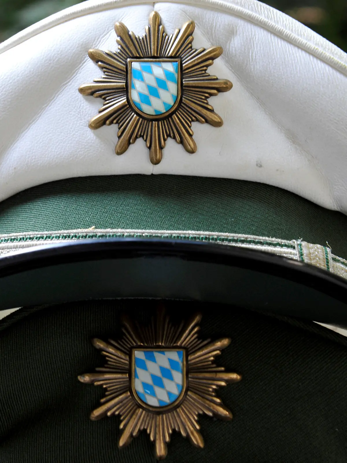 ILLUSTRATION - Polizeimützen liegen am Donnerstag (26.07.2012) auf einem Tisch einer Polizeistation in München (Oberbayern). Bayerns Polizei steht in den nächsten Jahren vor einer großen Pensionierungswelle. Bayerns Innenminister Herrmann will verhindern, dass aus Ruhestandsversetzungen ein Sicherheitsproblem wird. Foto: Frank Leonhardt dpa/lby  +++(c) dpa - Bildfunk+++