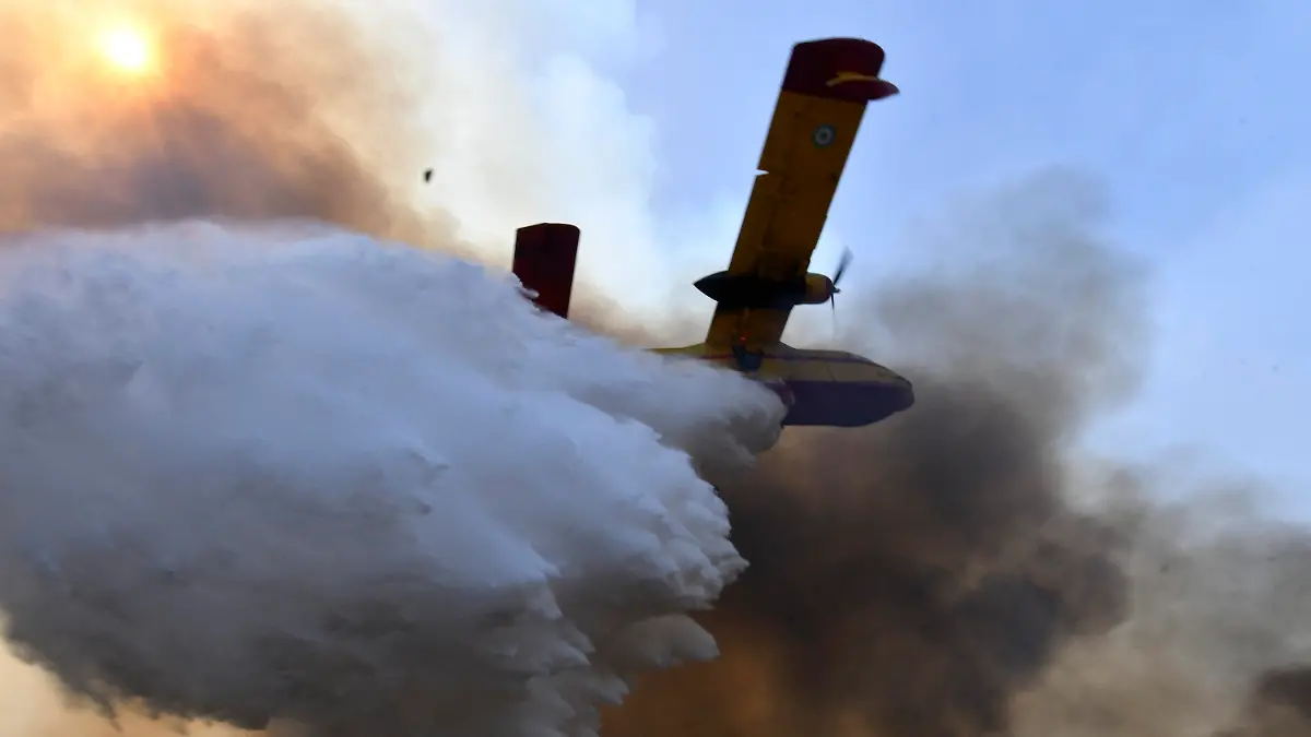 dpatopbilder - 05.08.2021, Griechenland, Olympia: Ein Flugzeug wirft Löschwasser über einem Waldbrand ab. Einsatzkräfte sind nach wie vor im Einsatz und bekämpfen Waldbrände. Das Feuer nördlich von Athen ist erneut voll aufgeflammt. Foto: Giannis Spyrounis/ilialive.gr/AP/dpa +++ dpa-Bildfunk +++